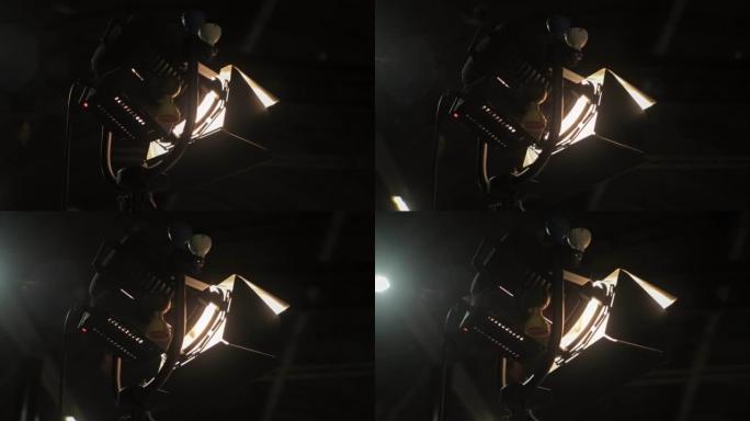 恒定照明设备的卤素源。在拍摄胶片时，轻型菲涅耳聚光灯探照灯处于设置状态。灯头。黑暗的舞台，场景。电影