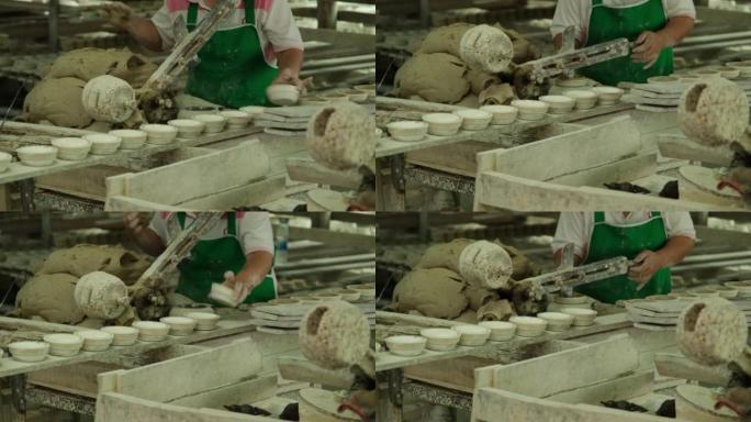 在陶器车间制作粘土的女人。制作手工陶瓷碗的过程。手工艺和小企业概念。