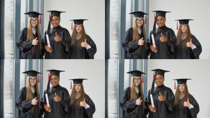 三名不同种族的女学生手里拿着文凭。穿着黑色长袍和方形帽子的毕业生微笑着看着镜头。欧美高等教育大