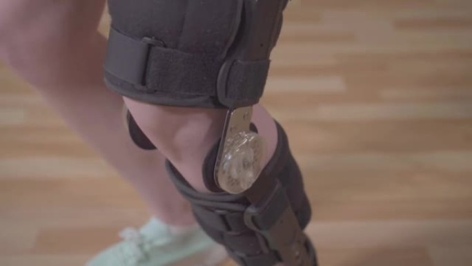 受伤后用矫形器护膝的女性腿特写