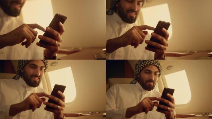 微笑的阿拉伯人使用智能手机特写。开朗的男人在手中刷手机