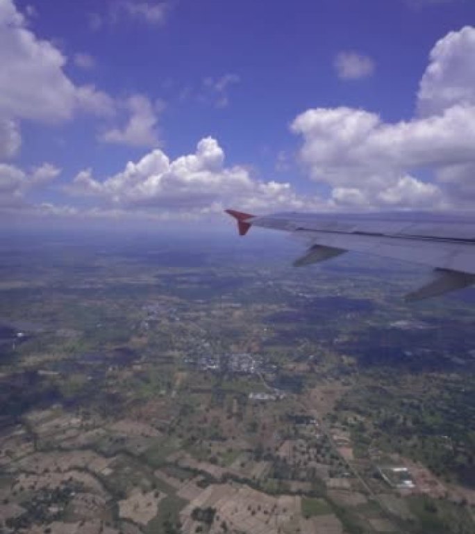 View Through Airplane Window over cloudy and the b