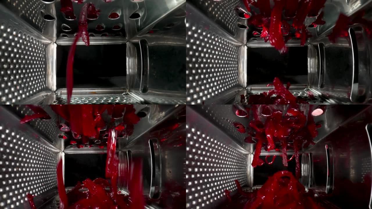 黑色背景上金属刨丝器光栅红色甜菜根的内部视图。用于研磨、切碎或切割的厨房用具。不锈钢厨房工具特写。餐