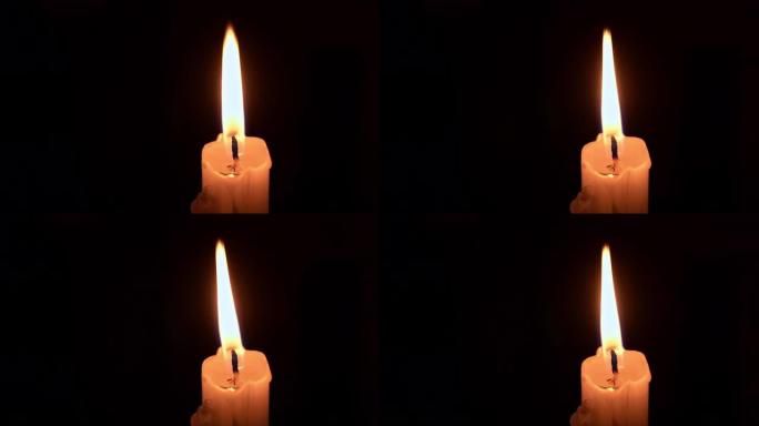 石蜡蜡烛在黑暗中燃烧着黄色火焰