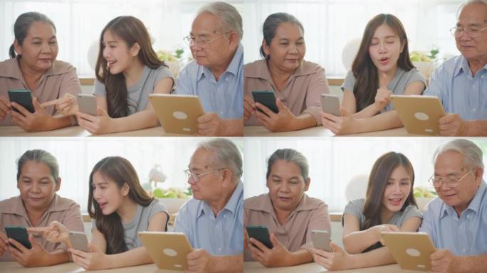 亚洲幸福家庭，资深父母在家与女儿使用手机。迷人的美丽女孩教老年夫妇在家里的厨房里用智能手机在线聊天。