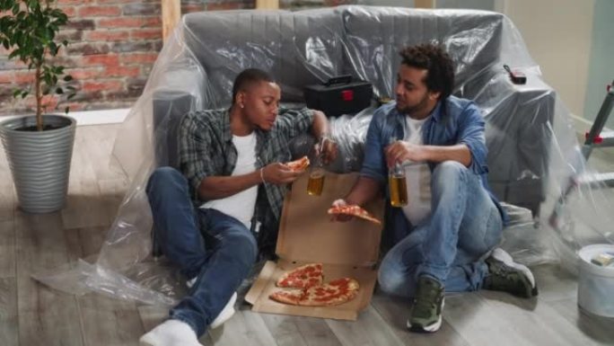 带啤酒瓶的非裔美国人兄弟吃新鲜的披萨