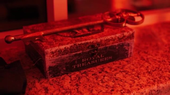 大型铁童话宝藏钥匙躺在闪烁的红灯中的木箱上