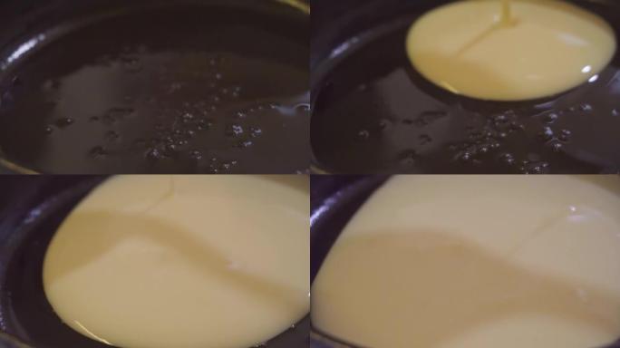 用液体面团制作煎饼的过程。用植物油润滑的黑锅，将面团倒在上面