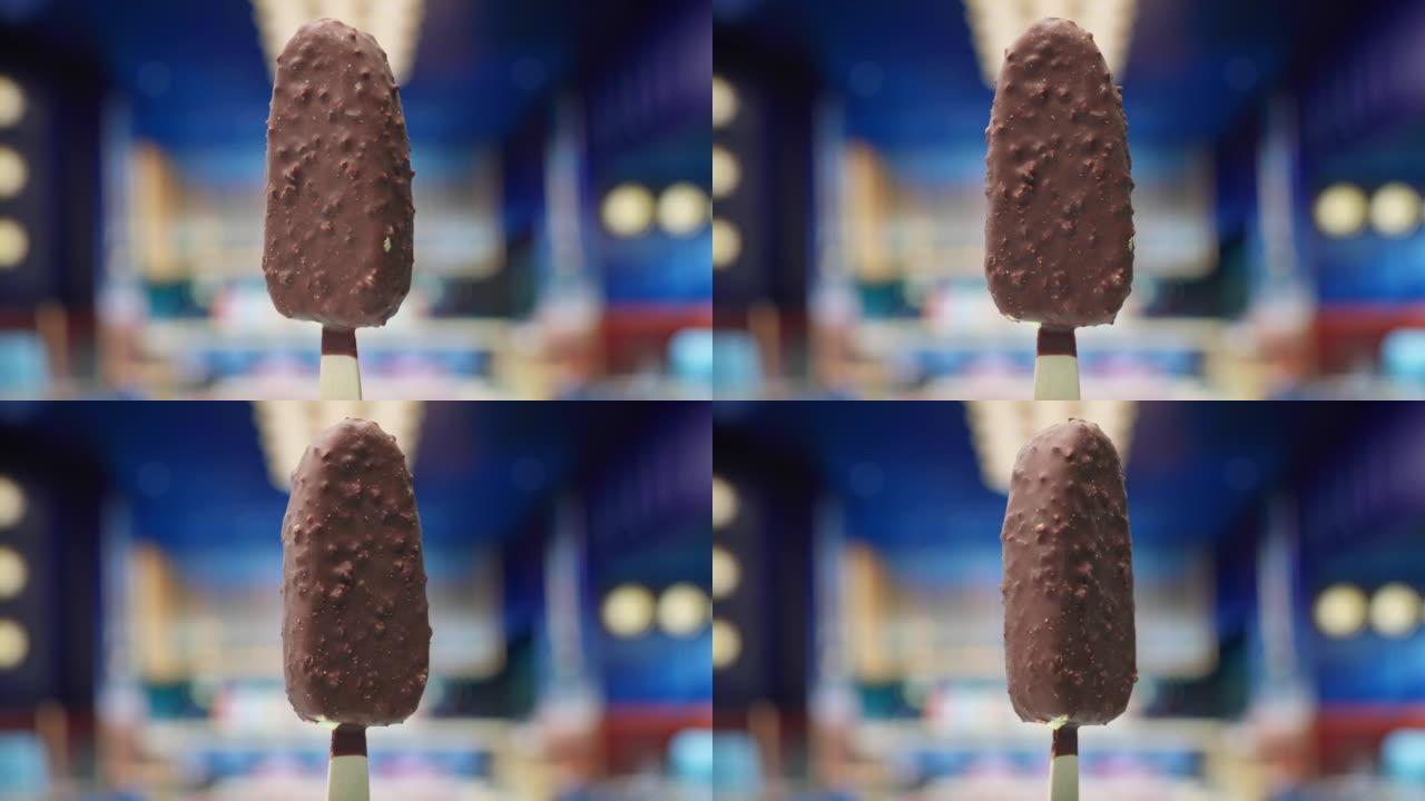 慢动作旋转的棍子上的巧克力冰淇淋。巧克力釉加坚果冰淇淋