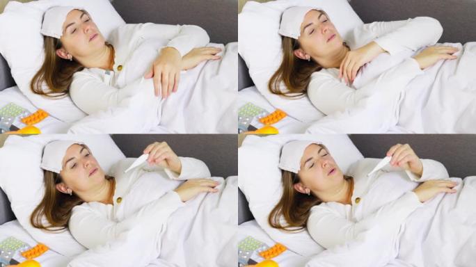 患有重感冒，流感或冠状病毒的女人发热躺在床上，靠近桌子上的药，她正在用温度计测量体温。生病的女人
