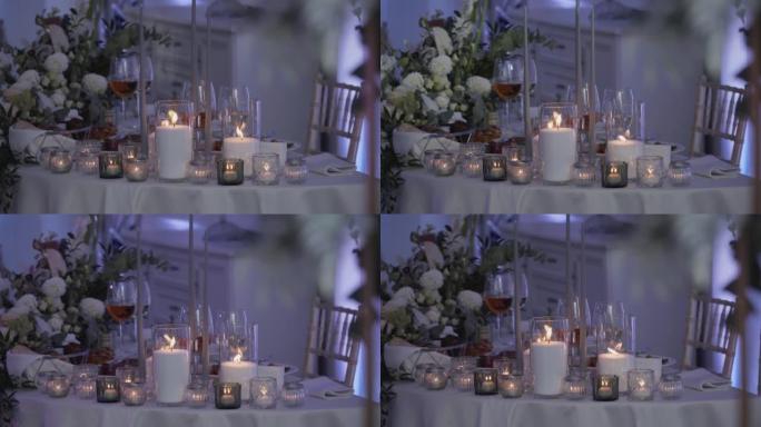 浪漫晚餐。桌子上装饰着烛台，上面放着燃烧的蜡烛和花。