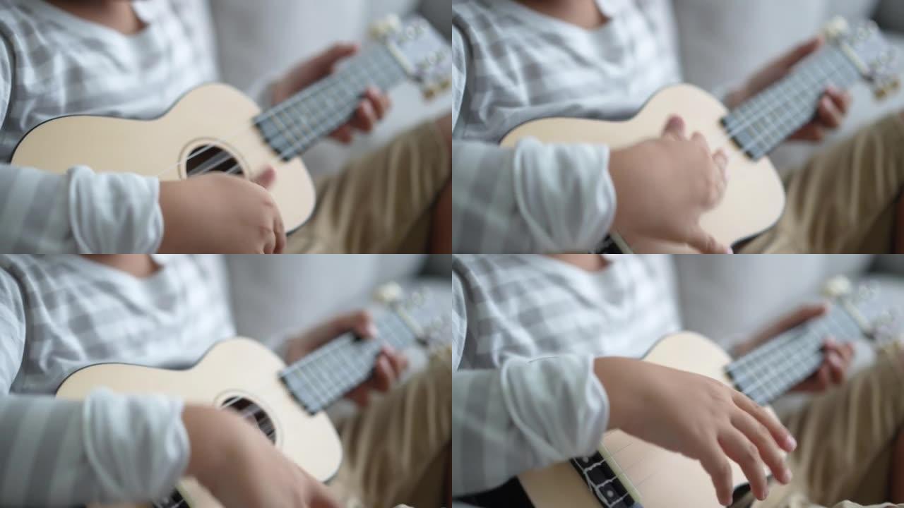 亚洲男孩在家练习吉他和四弦琴。学习和幸福的概念