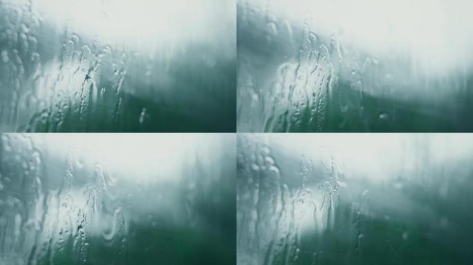 雨水形成的水滴流入窗户上的玻璃。4k，慢动作。