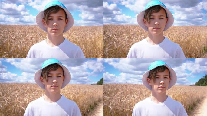 一个十几岁的男孩在麦田里看着相机的肖像，夏天阳光明媚的天气，移动的相机，steadicam镜头