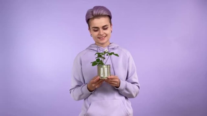 年轻时尚女性拿着锡罐，具有植物升级循环再利用概念