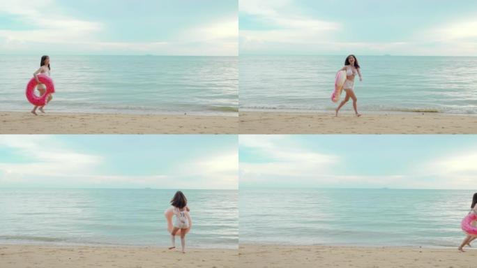 美丽的亚洲女子手持橡胶圈在沙滩上奔跑