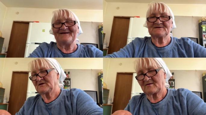 有着80年爱心的祖母为她的孙子和孩子们准备了饺子，她是家庭的监护人，她戴着白色围巾和蓝色外套，她坐在
