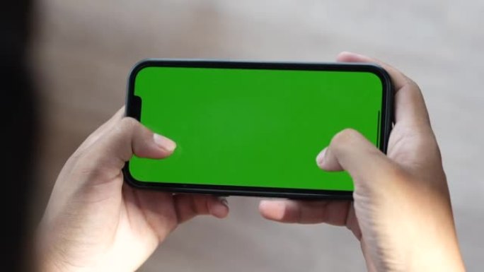 在绿色手机屏幕上玩游戏的人的特写