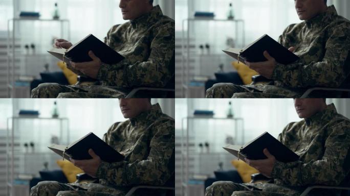 穿着军装的男子正在阅读圣经，翻页，祈祷和希望