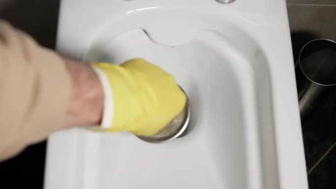 用刷子清洗马桶。用手套清洁浴室里的马桶