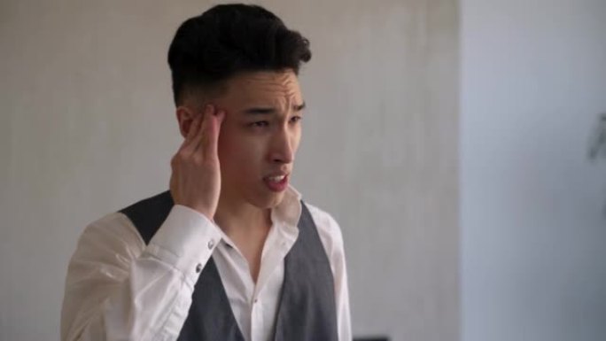 年轻的亚洲男子按摩患有头痛的寺庙