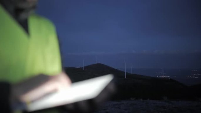 夜间在风电场工作的风能工程师。碳中和和可持续能源。