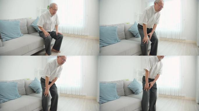 亚洲老人从家里客厅的沙发上站起来时膝盖疼痛。老人腿部疼痛。男性患有骨关节炎。老年人健康问题。