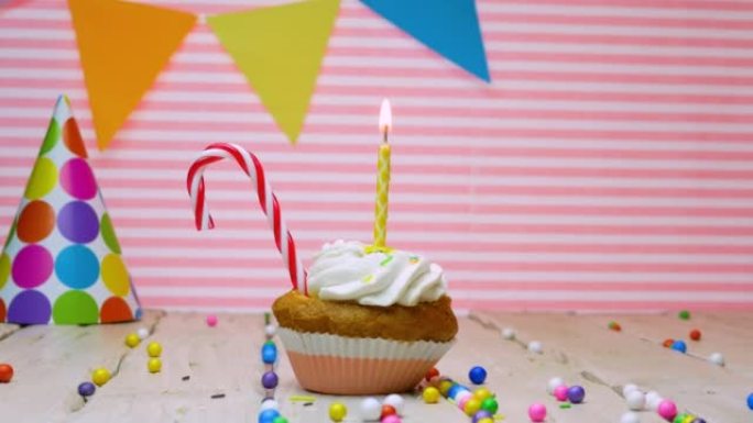 任何年龄的生日祝福，拷贝空间，美丽的视频背景快乐的生日粉红色的背景奶油纸杯蛋糕和蜡烛与火