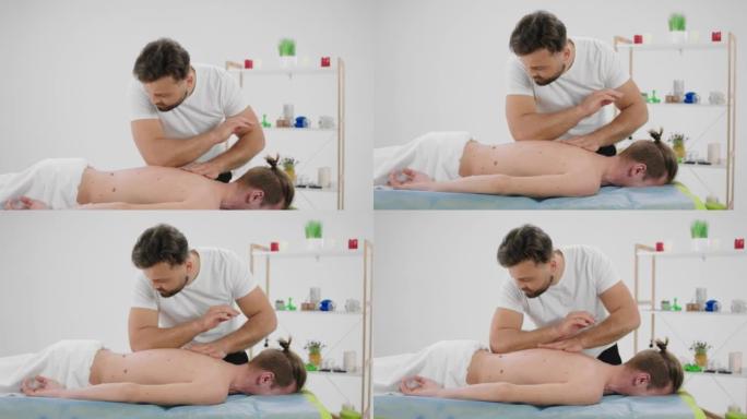 在水疗沙龙或按摩室，治疗师用手臂放松健康身体的概念对客户进行专业的手动按摩