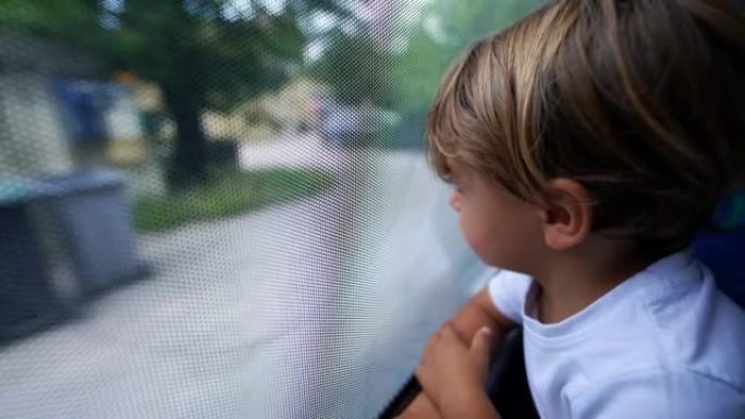 孩子盯着公共交通工具窗外