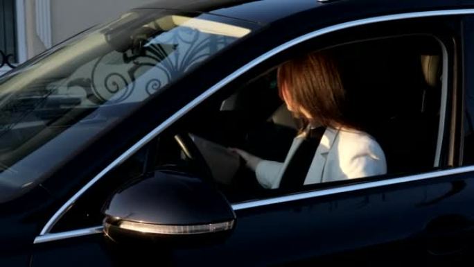 年轻而快乐的女商人在开车时通过车窗送包裹。快速交付的概念