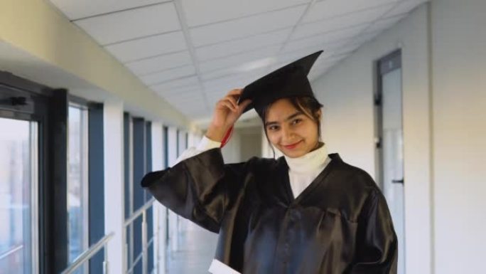 印度女毕业生穿着黑色长袍，在大学里戴着硕士帽。一个重要的事件。年轻专家