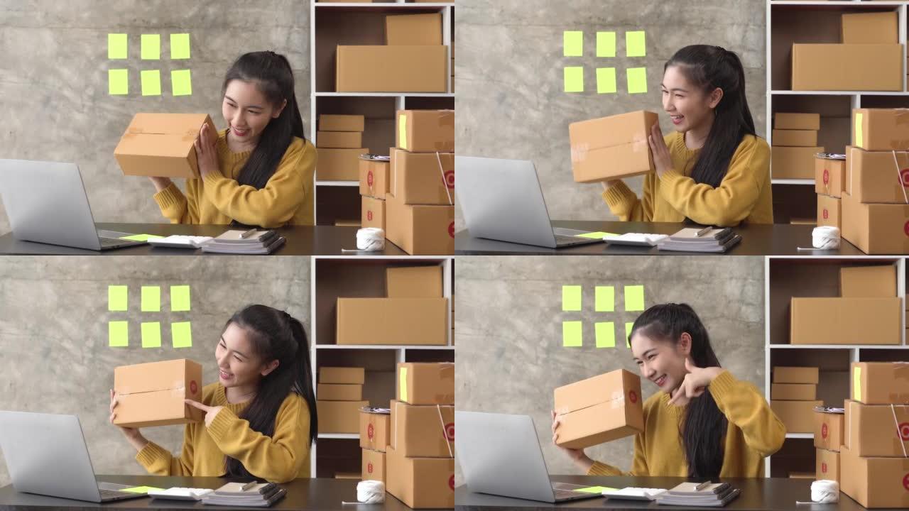年轻的亚洲女性展示包装盒，自由女性卖家检查产品订单。包装货物以交付给客户。