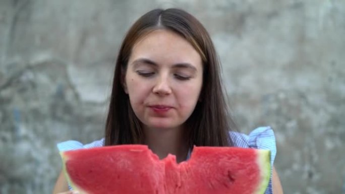 一个年轻漂亮的女人吃西瓜的肖像。