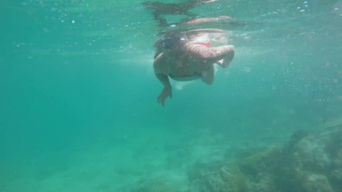 一个拉丁美丽的少女潜水、浮潜、游泳和漂浮时放松的高角度视角照片，在拉丁美洲厄瓜多尔加拉帕戈斯岛康沙德