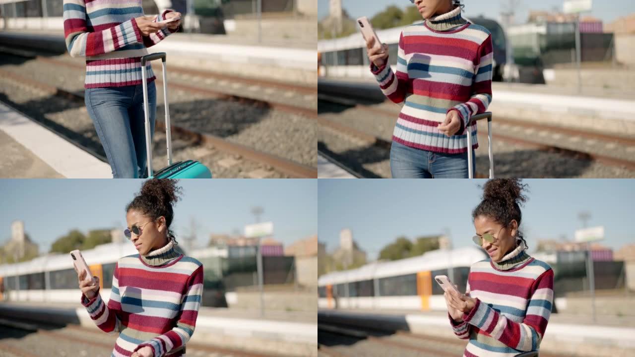 一个女人站在铁路平台上，拿着手机。