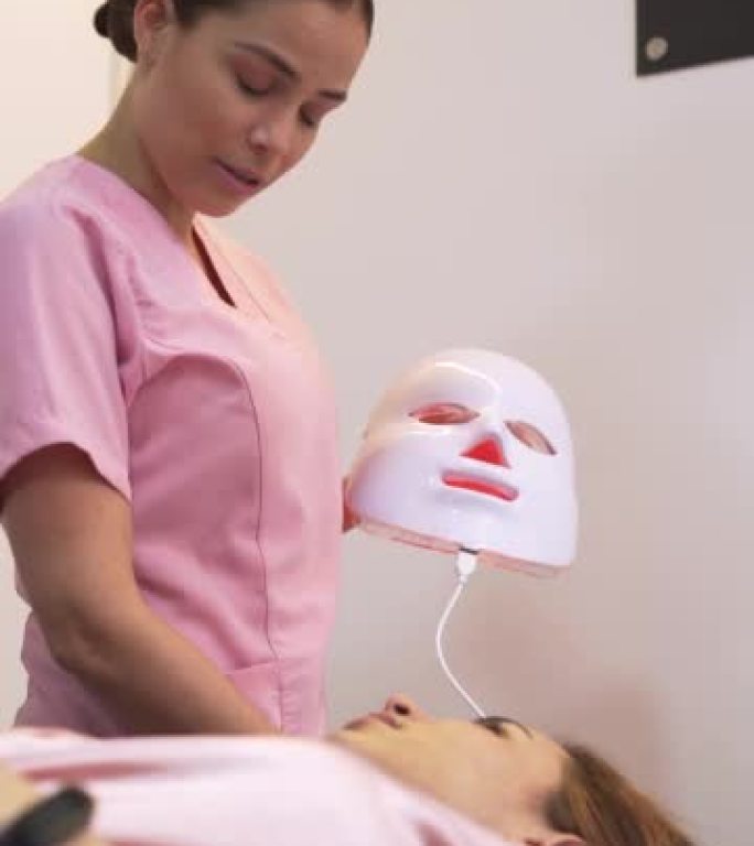 专业的女性美容师对客户的面部进行美容治疗