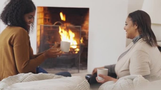 母女俩在舒适的壁炉旁喝咖啡放松