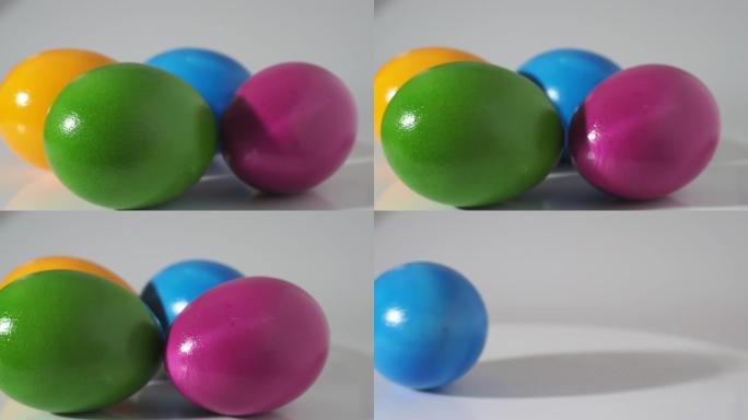 彩色鸡蛋在白色背景上旋转。彩绘鸡蛋特写。