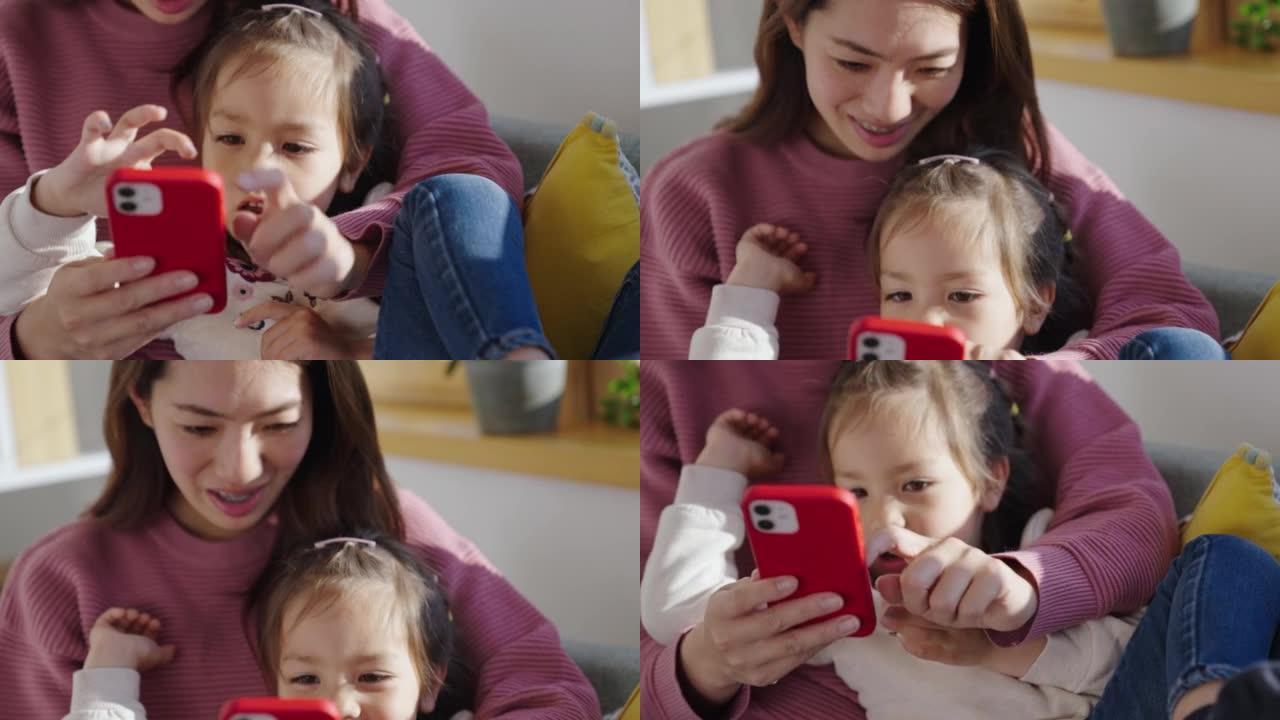 妈妈和可爱的小女儿一起用手机看动画片