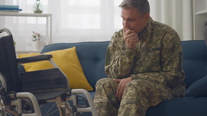 抑郁的士兵坐在轮椅旁的教练，遭受战后创伤后应激障碍危机