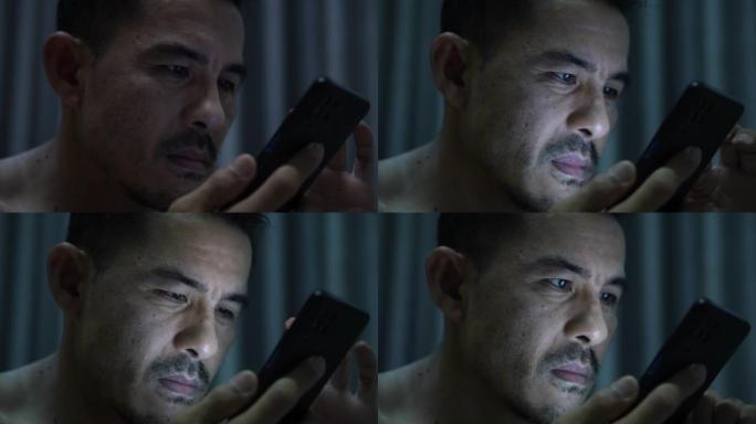 一名男子的特写镜头在晚上在线使用智能手机。