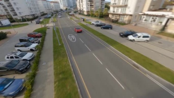 空中fpv视图红色跑车法拉利波托菲诺敞蓬车骑在沥青路市区当地基础设施上。汽车交通城镇街道房屋交通
