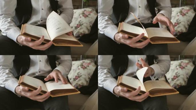 一个人的手在看书时转动了一本书的书页。特写镜头。看书的家伙