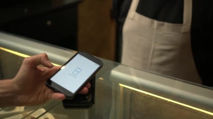 客户在商业商店内的智能手机设备上使用非接触式NFC支付技术进行支付