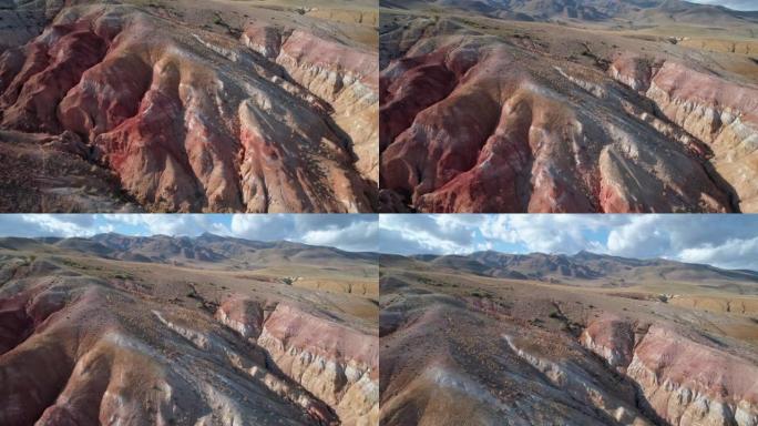 俄罗斯阿尔泰地区美丽的彩虹山脉的空中倾斜拍摄。称为火星的地质构造。由于矿物的沉积，砂岩山链被多色图案