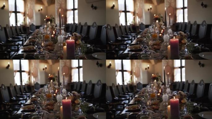 黑暗房间里漂亮的桌子布置。桌子上装饰的鲜花、蜡烛。