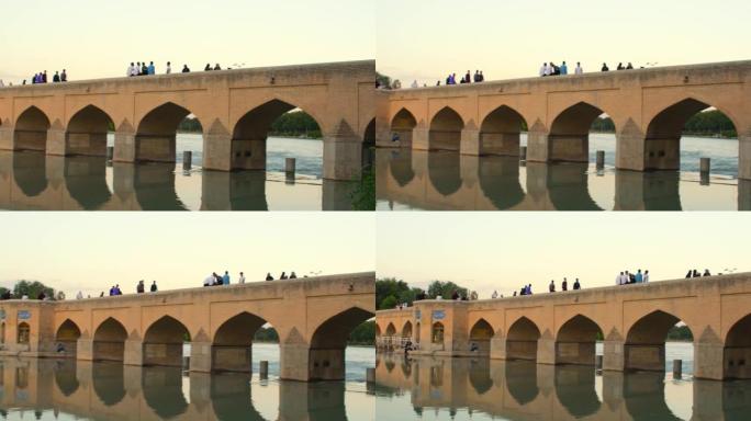伊朗伊斯法罕-6月15日，2022: 人们走在伊斯法罕古老的历史旧拱桥上