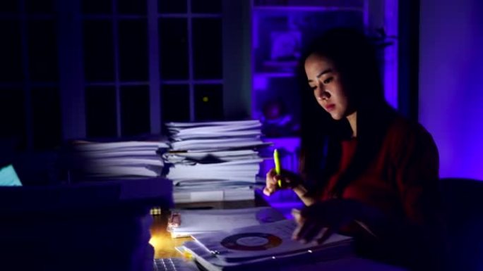 亚洲女商人在线在家用笔记本电脑努力工作。晚上加班又忙又累。