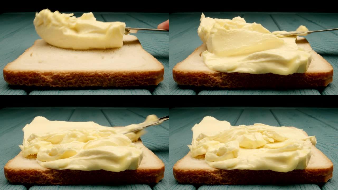宏观: 大块黄油用小刀铺在蓝色木质背景上的面包上
